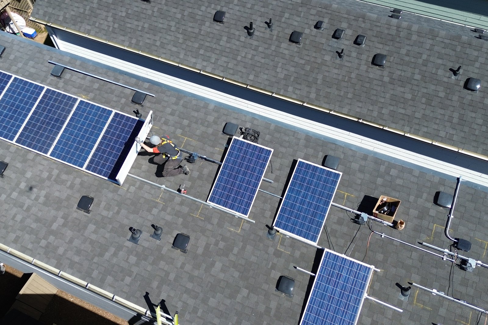 An installer securing a solar panel to the roof mounting rails